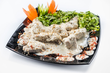 Gedlibzhe — kabardian chicken in sour cream sauce with onion garlic and spices in a frying pan close up