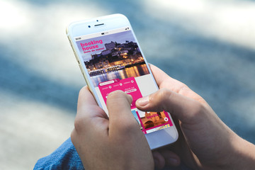 Woman with smartphone booking a hotel on application