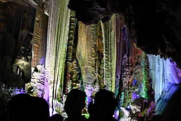 Fototapeta na wymiar beautiful illuminated multicolored stalactites from karst Reed Flute cave In the cave. Guilin Guangxi China