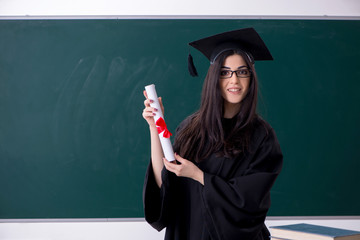 Female graduate student in front of green board 