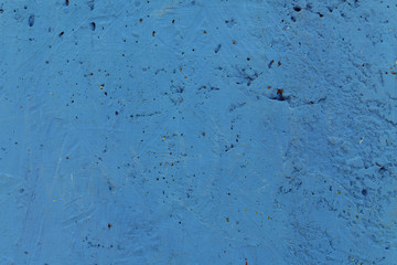 Blurred abstract background. Texture painted rough concrete surface with cracks and holes of light blue color. Cropped shot, horizontal, place for text, nobody. The concept of repair.