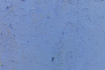 Blurred abstract background. Texture painted rough concrete surface with cracks and holes of light blue color. Cropped shot, horizontal, place for text, nobody. The concept of repair.