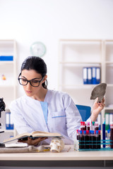 Young female archaeologist working in the lab 