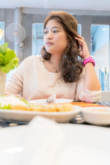 Obraz na płótnie Canvas Asian women eating food, sitting in a restaurant.