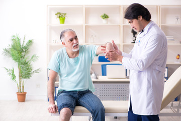 Obraz premium Old man visiting young male doctor 