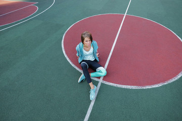 A woman in sports clothes looks straight at the camera. A woman after a morning workout on the playground.