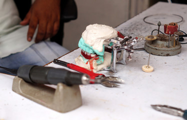 View of Indian dental technician making dentures