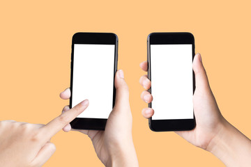 two hands holding and playing smart phones on yellow background with clipping path