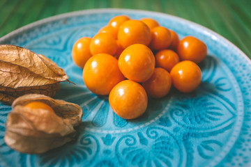 Fresh physalis on a blue plate - complementary colors