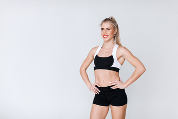 Obraz premium Muscular young woman athlete on gray.