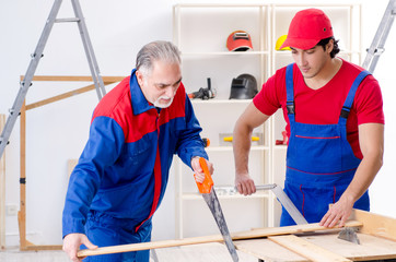 Two professional contractors laying flooring at home  