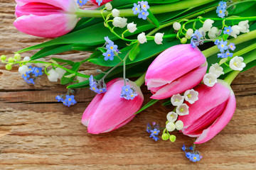 Bouquet of pink tulips, lily of the valley and forget me not flowers.
