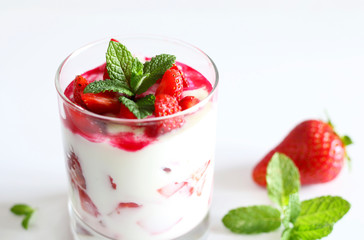 Dessert in bicchieri con fragole fresche e yogurt, su sfondo bianco
