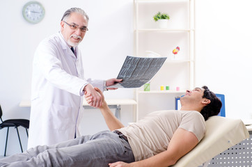 Young man visiting old male doctor radiologist 