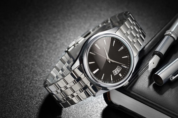 Steel wristwatch on black background