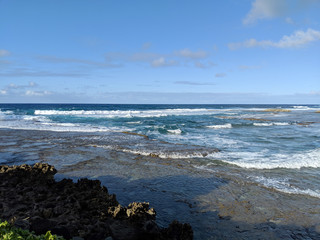 Fototapeta na wymiar Waves break over rocks at Kuilima Cove