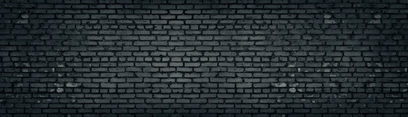 Wide old dark gray shabby brick wall texture. Black masonry panorama. Brickwork panoramic grunge...