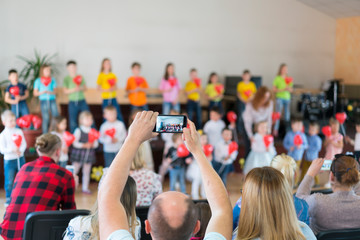 Performance by talented children. Children on stage perform in front of parents. image of blur kid 's show on stage at school , for background usage. Blurry