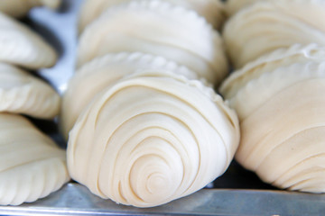 empanadas lined up before fried, curry puff ready to fried on table