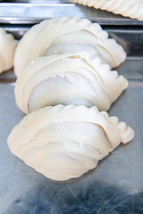 empanadas lined up before fried, curry puff ready to fried on table