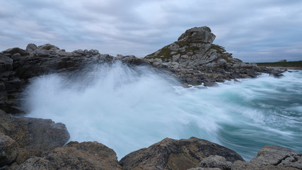 Langzeitbelichtung des dramatischen Himmels mit dunkelblauen Wolken über der felsigen bretonischen Küste, Frankreich, Bretagne, Finistere