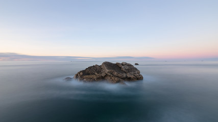 Langzeitbelichtung von großen Felsen im Meer bei Sonnenuntergang, Frankreich, Bretagne, Finistere