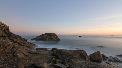 Langzeitbelichtung des Sonnenaufgangs an der felsigen bretonischen Küste in Frankreich, Bretagne, Finistere