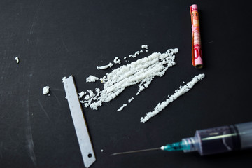 Cocaine and selective focus on Indonesia rupiah ready for uses on dark table