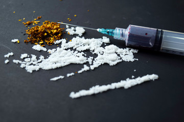 Cocaine and Selective focus on syringe ready for uses on dark table.