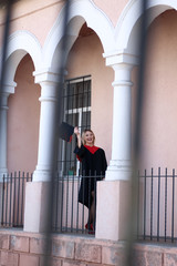student in academic dress holds a diploma