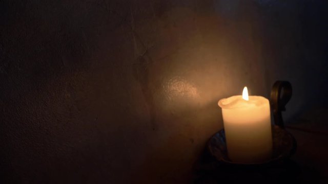 Retro vintage candle light and old decoration stone wall wooden table in the dark