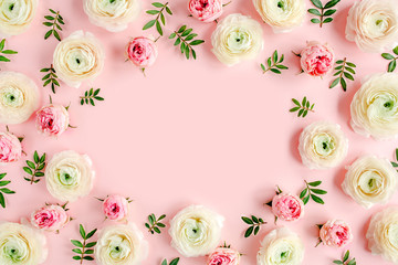 Floral background frame made of pink ranunculus and roses flower buds on pink background.  Flat...