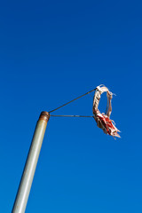worn out windsock against blue sky