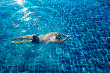 Obraz premium Young athletic man swimming in the swimming pool