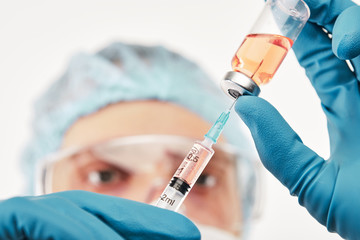 Nurse filling up syringe with medicine