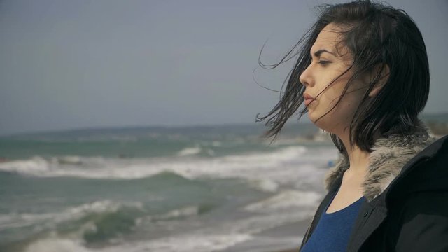 depressed sad lonely young woman contemplating the ocean-slow motion