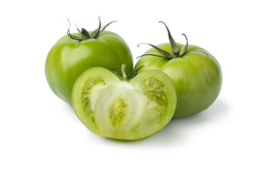 Whole and halved green unripe tomatoes
