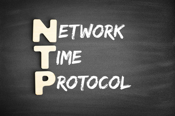 Wooden alphabets building the word NTP - Network Time Protocol acronym on blackboard
