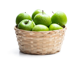 Ripe green apples in wicker basket isolated on white