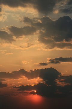 Beautiful light of the sun from behind dark clouds in the evening sky at sunset