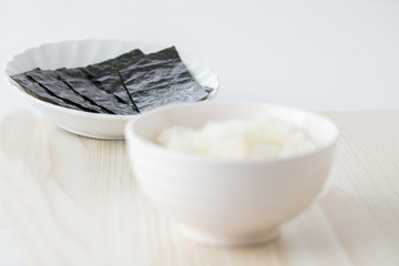 白背景に白いご飯に海苔を巻いて食べる日本人お米日本食