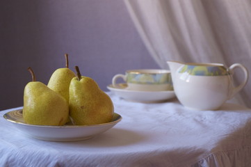 Green pears in bowl on table
