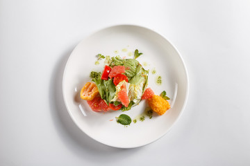 Food on white plate. Side dish. Greenery. Fruits. Vegetables.