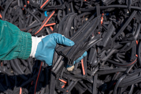 Close up of man holding pieces of waste shredded rubber