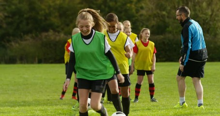4K Happy teen girls smiling, having fun at soccer training with sports coach. Slow motion. - Powered by Adobe