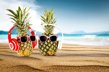 Summer photo of beach and fresh pineapple on sand 