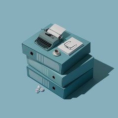 Miniature vintage typewriter on a pile of folders