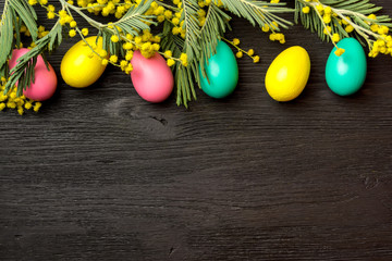 Easter background with mimosa, eggs and wooden surface
