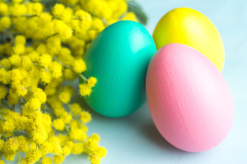 Fototapeta na wymiar Easter background with mimosa, eggs and blue surface