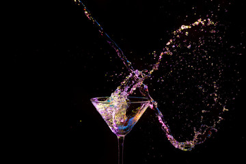 High Speed Splash Photography. Burst of Colorful Liquid in Wine Glass. Isolated Over Black.